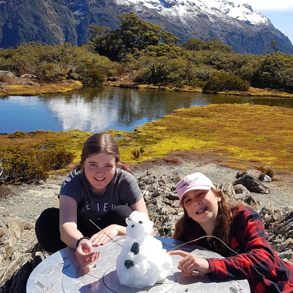 Children makeing a snowman on the Key Summit Guided Walk with Fiordland Walks